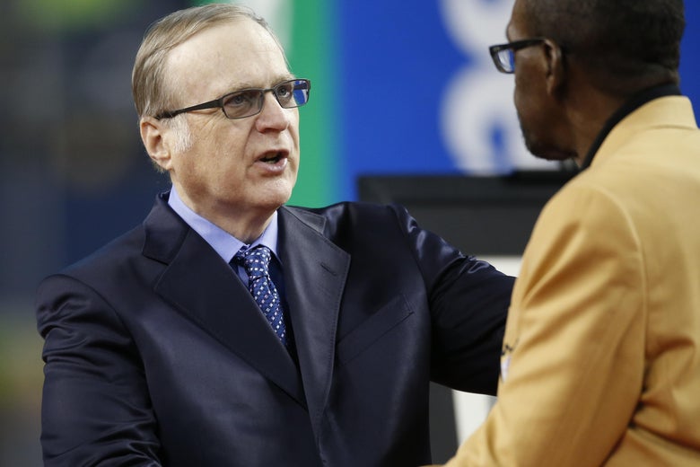 Paul Allen greets an NFL Hall of Fame member during halftime of a Seahawks game.